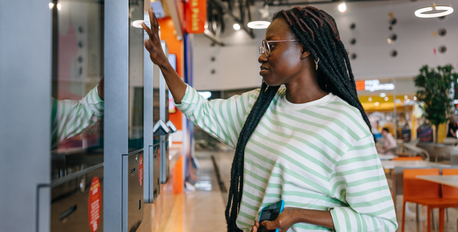 woman using kiosk in QSR