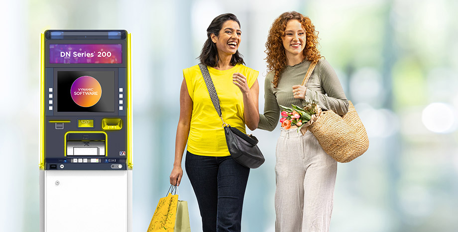 2 women walking by an ATM