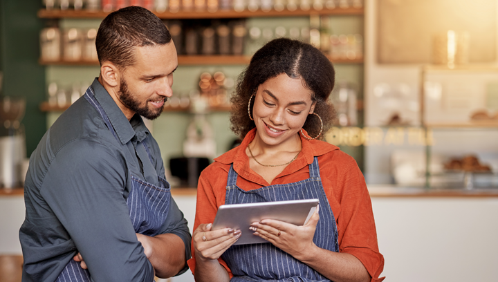 2 cafe employees working together on a tablet
