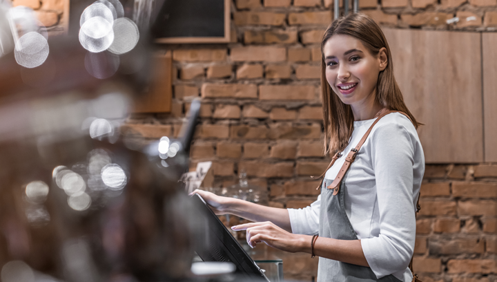 Cafe employee using POS machine